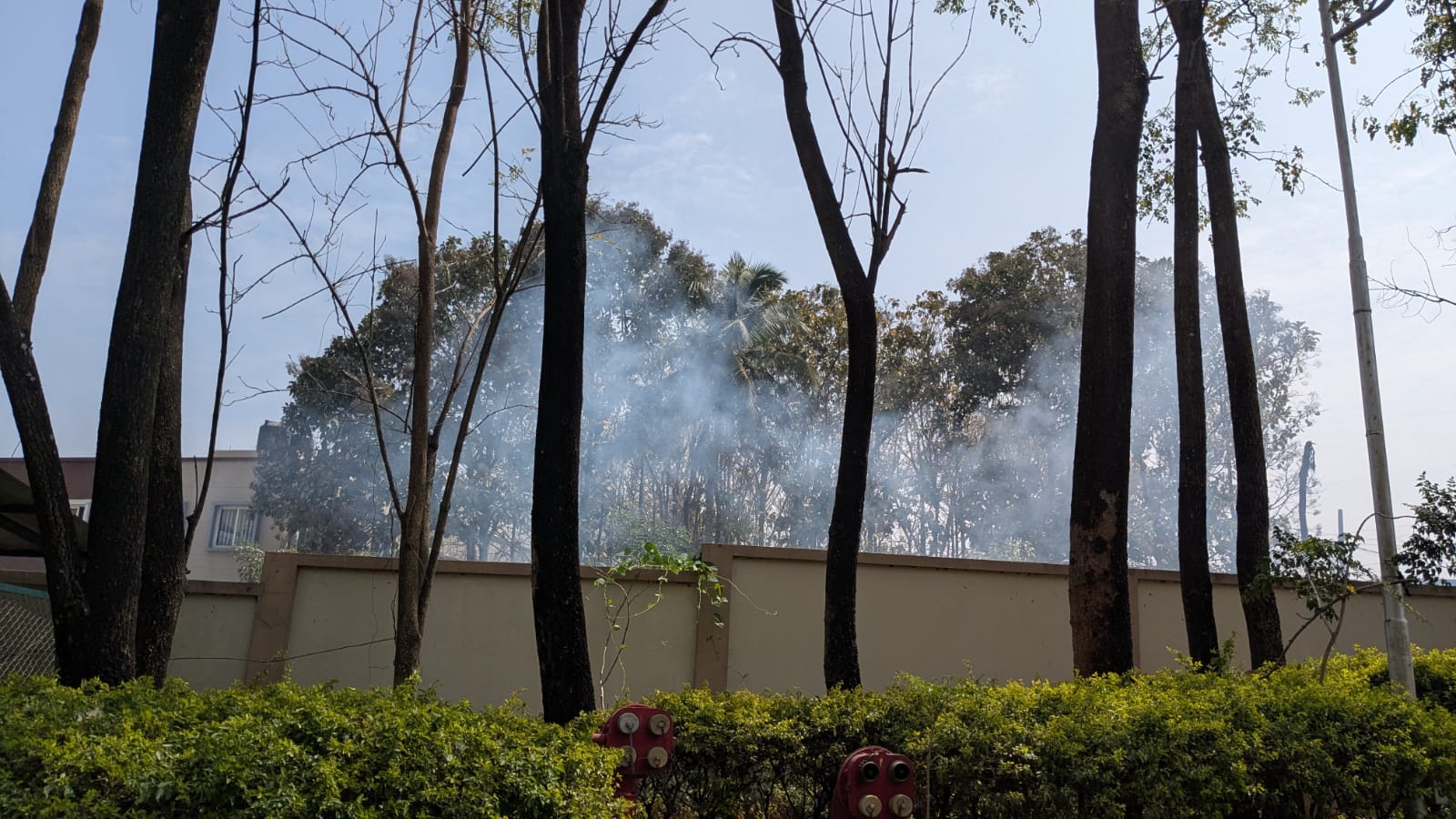 Smoke visible over the boundary wall of Mantri Tranquil